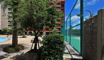 a swimming pool with a tree and a building at Studio 777 Condo MaiKhao in Ban Mai Salae
