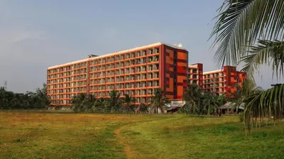 a large red building with palm trees in front of it at Studio 777 Condo MaiKhao in Ban Mai Salae