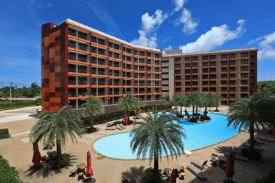 a hotel with a pool and palm trees and a building at Studio 777 Condo MaiKhao in Ban Mai Salae