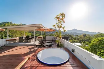 an outdoor deck with a table and an umbrella at Great sea View Roof Top V163 in Kamala Beach