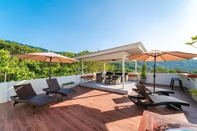 a patio with chairs and umbrellas on a deck at Great sea View Roof Top V163 in Kamala Beach