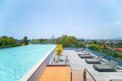 a swimming pool with lounge chairs on the roof of a building at Oceanstone Condo 2 bedrooms BangTao Laguna in Bang Tao Beach