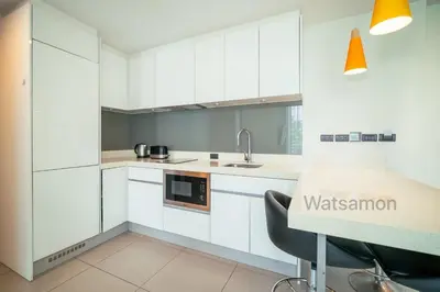 a kitchen with white cabinets and a sink at Oceanstone Condo 2 bedrooms BangTao Laguna in Bang Tao Beach