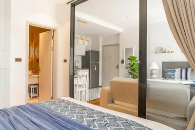 a bedroom with a bed and a living room at Title Halo I Sea You Naiyang Pool Gym Sauna in Nai Yang Beach