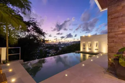 an infinity pool in a house with a sunset at Patong 180-degree stunning sea view modern 4-bedroom villa sleeps 10 private pool stunning sunset BBQ in Patong Beach