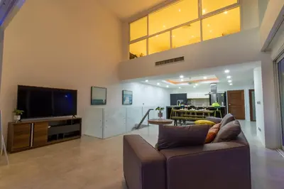 a living room with a couch and a television at Patong 180-degree stunning sea view modern 4-bedroom villa sleeps 10 private pool stunning sunset BBQ in Patong Beach
