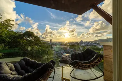 a view of a city from a balcony with chairs at Patong 180-degree stunning sea view modern 4-bedroom villa sleeps 10 private pool stunning sunset BBQ in Patong Beach