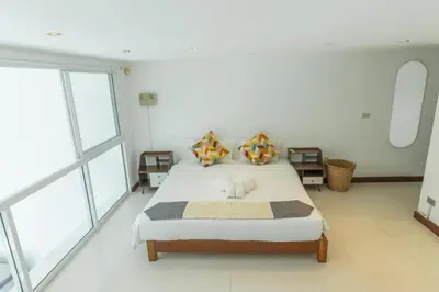 a bedroom with a bed in a room with windows at Patong 180-degree stunning sea view modern 4-bedroom villa sleeps 10 private pool stunning sunset BBQ in Patong Beach