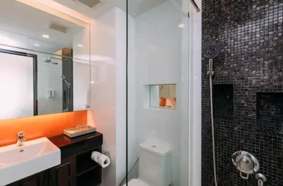 a bathroom with a toilet and a sink and a shower at the beach height resort by sahana in Kata Beach