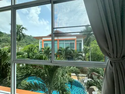 an open window with a view of a house at Kamala Evergreen Home in Kamala Beach