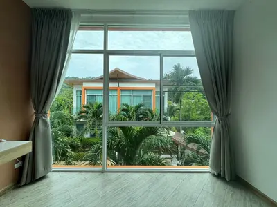 a large window with a view of a house at Kamala Evergreen Home in Kamala Beach