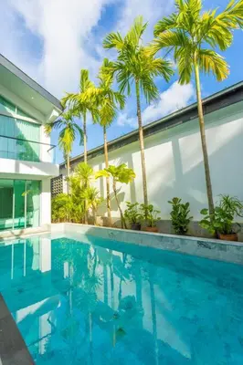 a swimming pool with palm trees in front of a building at Nicest In Phuket 4Br 1 km Bang Tao Beach V141 in Bang Tao Beach