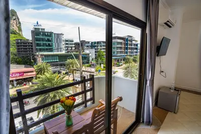a room with a balcony with a view of a city at The BRC Ao-nang Hotel in Ao Nang Beach