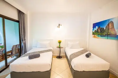 two beds in a hotel room with a window at The BRC Ao-nang Hotel in Ao Nang Beach