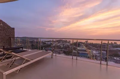 a balcony with a view of a city at sunset at Best View In Phuket! 2 Living Rooms 4 BR #C80 in Karon Beach