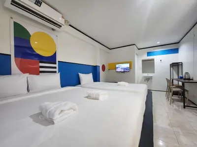 a bedroom with a large white bed with towels on it at RYB Hostel Phuket in Ban Lo Long