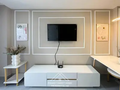 a living room with a tv on a wall at Tower condo Rawai Phuket 305 in Ban Klang