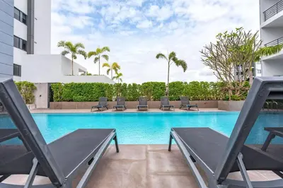 a swimming pool with lounge chairs in a building at Tower condo Rawai Phuket 305 in Ban Klang