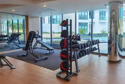 a gym with treadmills and machines in a building at La Vita Stylish apartment in 5 star hotel in Rawai Beach