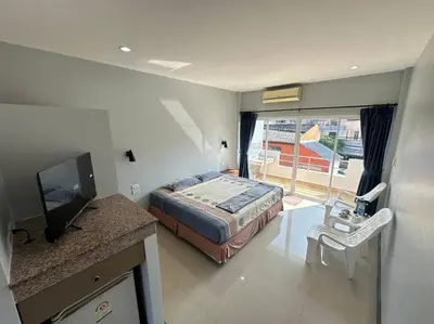 a bedroom with a bed and a television and a balcony at \u30a2\u30de\u30c6\u30e9\u30b9\u30d1\u30c8\u30f37 in Patong Beach