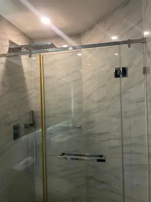 a shower with a glass door in a bathroom at Oceana Kamala Stunning corner Suite Sea View in Kamala Beach