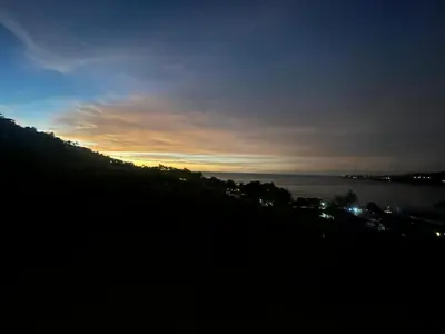 a view of the ocean at night with the sunset at Oceana Kamala Stunning corner Suite Sea View in Kamala Beach