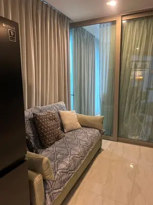 a living room with a couch in front of a window at Oceana Kamala Stunning corner Suite Sea View in Kamala Beach
