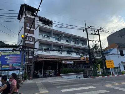 a building on the corner of a street with people walking at \u30d1\u30c8\u30f3\u30eb\u30fc\u30e01 in Patong Beach
