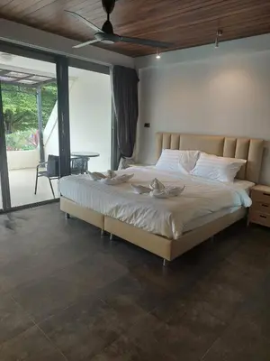 a bedroom with a large bed and a table at The green golf resident 106 in Kathu