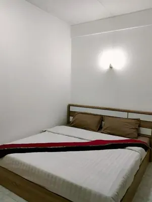 a bed in a bedroom with a white wall at Nice to CU Guest house in Patong Beach