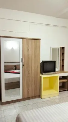 a room with a bed and a tv on a table at Nice to CU Guest house in Patong Beach