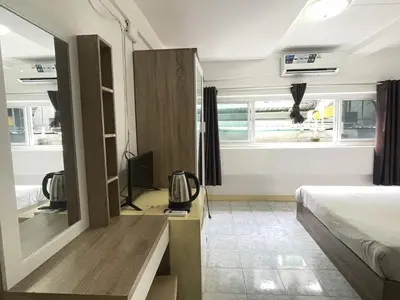 a bedroom with a bed and a television in it at Nice to CU Guest house in Patong Beach