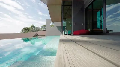a house with a swimming pool next to a building at Villa Noon in Patong Beach