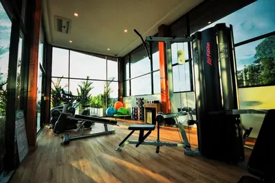 a gym with two treadmills in a room with windows at Villa Noon in Patong Beach