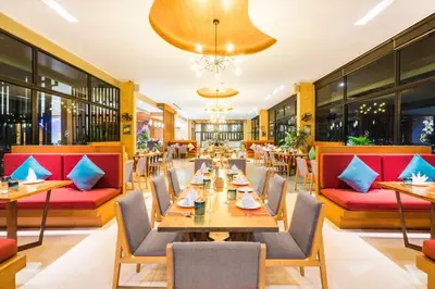 a restaurant with tables and chairs and a chandelier at Villa Noon in Patong Beach