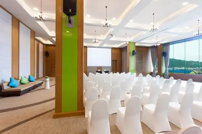 a conference room with white chairs and a projection screen at Villa Noon in Patong Beach