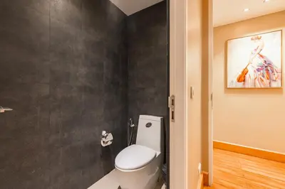 a bathroom with a toilet and a painting on the wall at \u82ad\u4e1c\u65e5\u6708\u53cc\u6d77\u666f\u522b\u5885 in Patong Beach