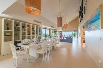 a dining room with a long table and white chairs at \u82ad\u4e1c\u65e5\u6708\u53cc\u6d77\u666f\u522b\u5885 in Patong Beach