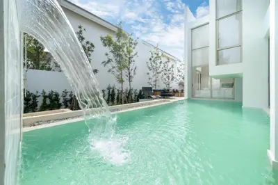 a water fountain in a swimming pool in a house at Sofia Villa Phuket in Phuket Town