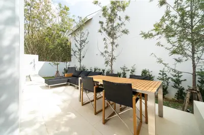 a patio with a wooden table and chairs at Sofia Villa Phuket in Phuket Town