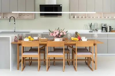 a kitchen with a wooden table with chairs and flowers at Sofia Villa Phuket in Phuket Town