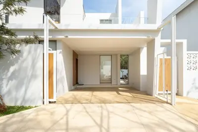 an external view of a white house with a hallway at Sofia Villa Phuket in Phuket Town