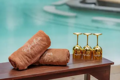 a table with two towels and three wine glasses at Café del Mar Phuket - Suite & Penthouse in Kamala Beach