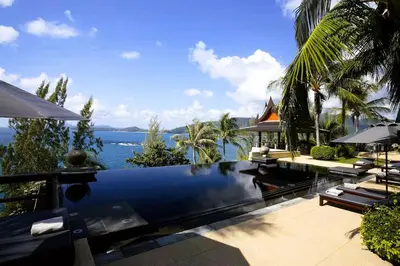a swimming pool with a view of the ocean at 00 - Thai Paradise on Kamala Bay in Amphoe Thalang