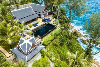 an aerial view of a house with a swimming pool and the ocean at 00 - Thai Paradise on Kamala Bay in Amphoe Thalang