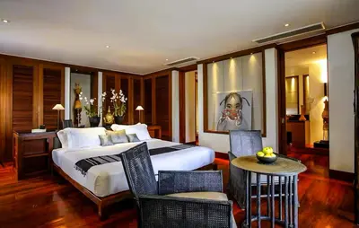 a bedroom with a large bed and a table and chairs at 00 - Thai Paradise on Kamala Bay in Amphoe Thalang