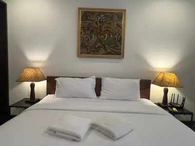 a bedroom with a white bed with two towels on it at VILLA AP Grand Residence in Kamala Beach
