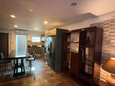 a kitchen with a dining table and a refrigerator at VILLA AP Grand Residence in Kamala Beach