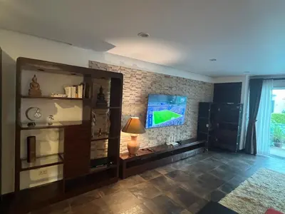 a living room with a tv on a brick wall at VILLA AP Grand Residence in Kamala Beach