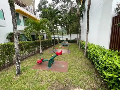 a playground in front of a building with palm trees at VILLA AP Grand Residence in Kamala Beach